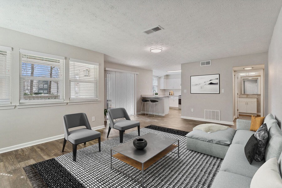 Model apartment living room with a couch and two chairs