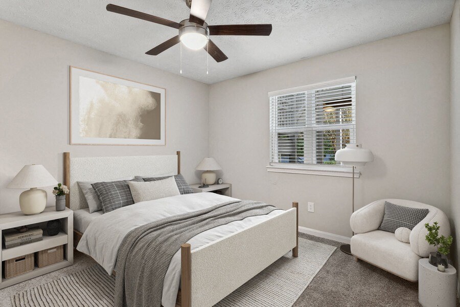Model apartment bedroom with a bed and a ceiling fan
