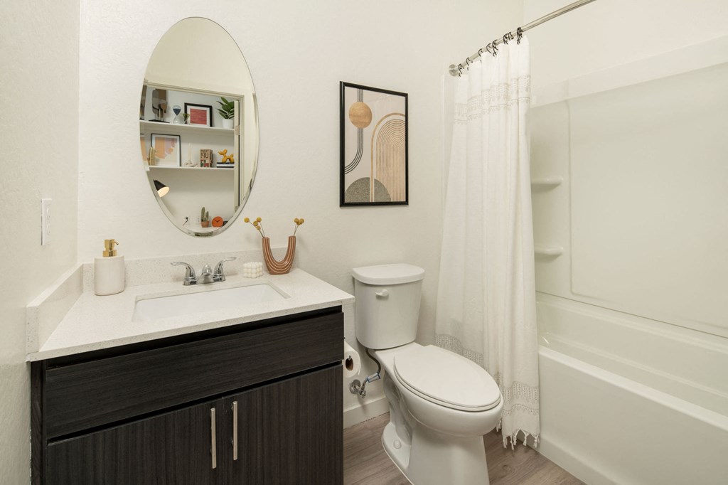 a bathroom with a white sink and toilet next to a white bathtub with a shower curtain