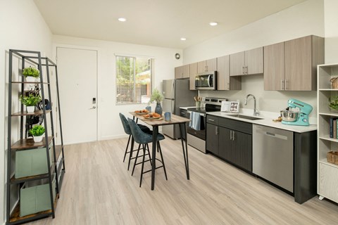 a kitchen with stainless steel appliances and a table with chairs