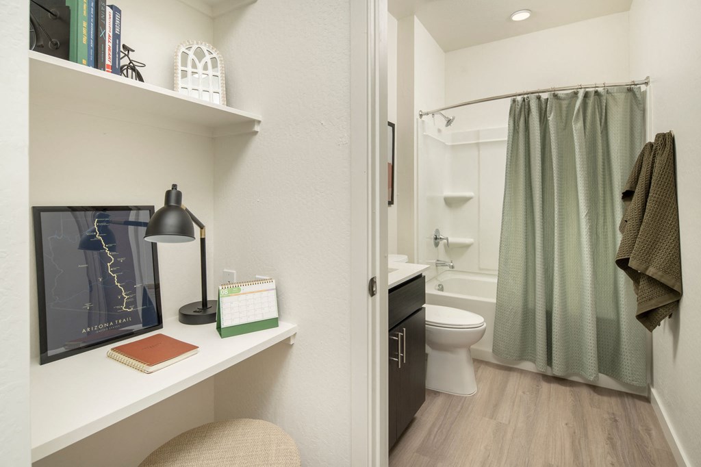 a bathroom with a white toilet next to a green shower curtain