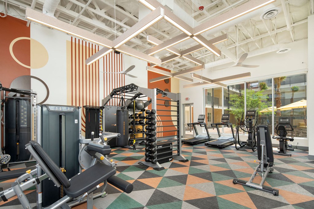 a view of the fitness center with a variety of exercise equipment