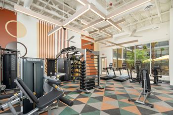 a view of the fitness center with a variety of exercise equipment