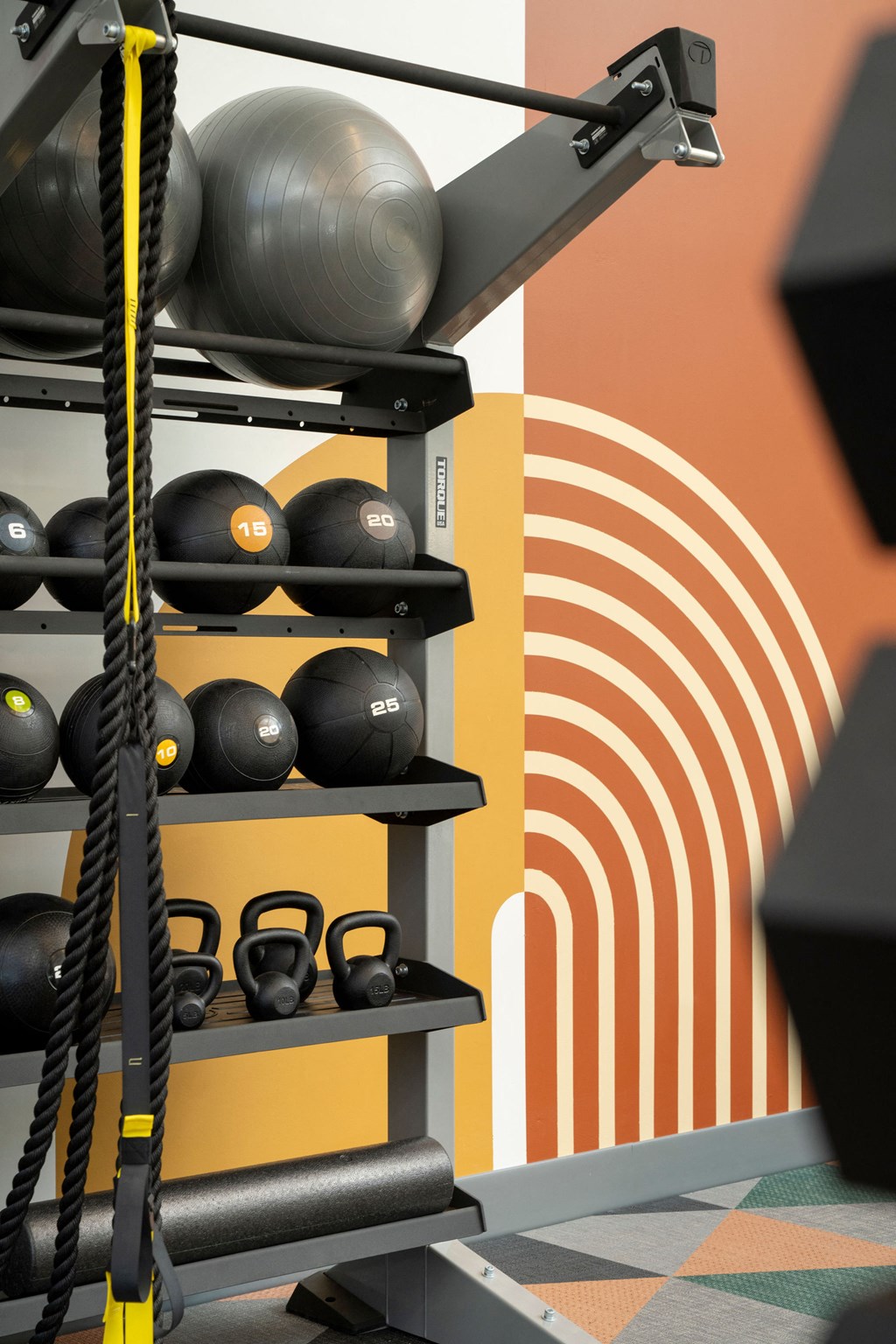a gym with weights and a wall with a graphic of a wave