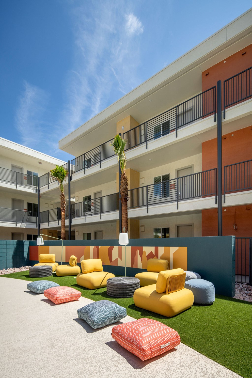 a seating area with couches and pillows in front of a building