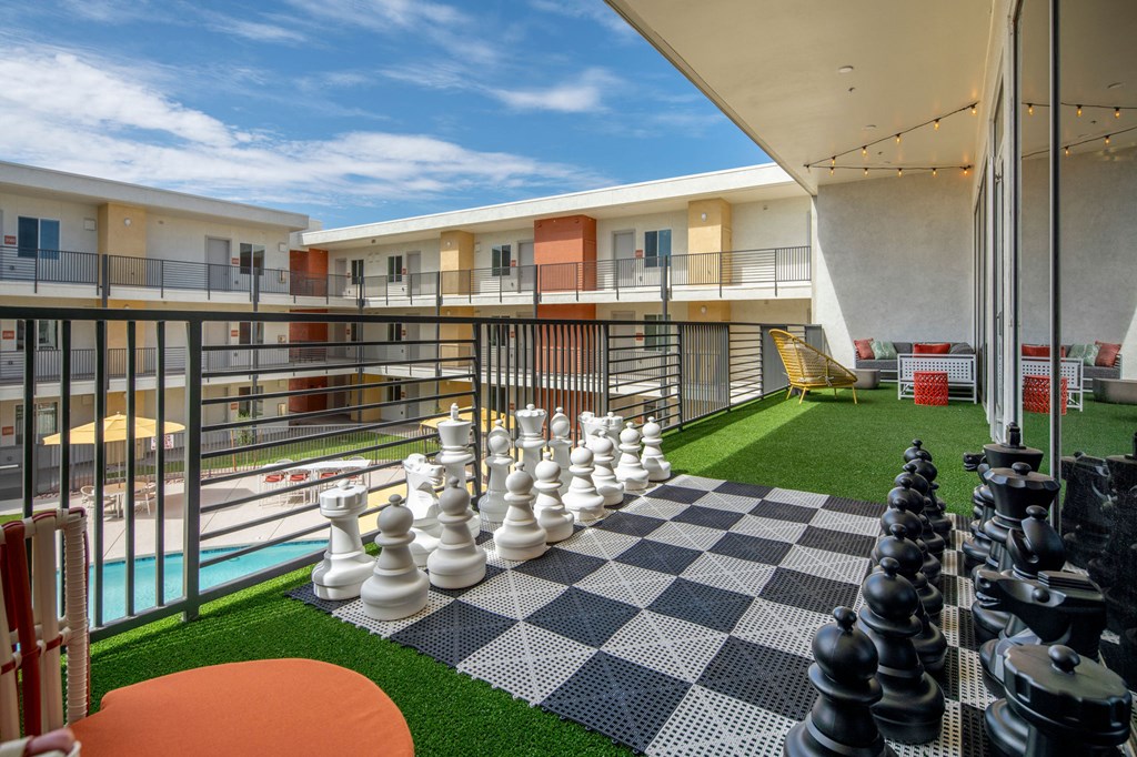 a large chess board on a balcony with a blue sky in the background