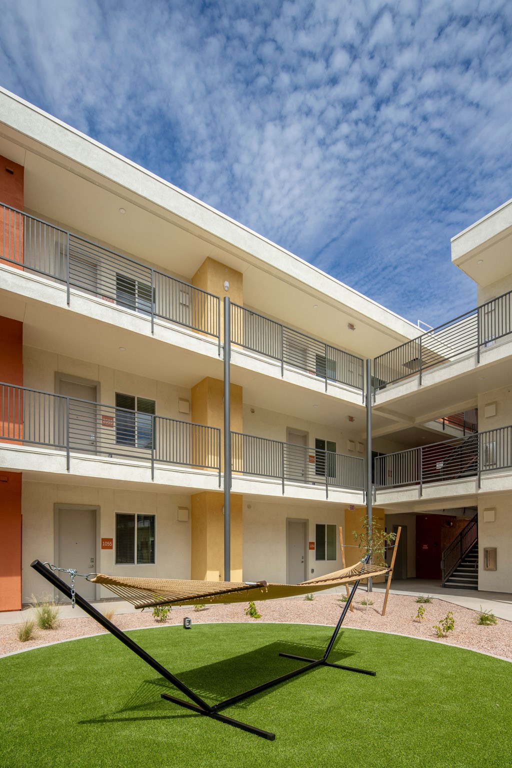 a hammock sits in the courtyard of an apartment building