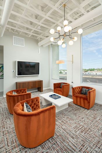 a living room with orange chairs and a white coffee table