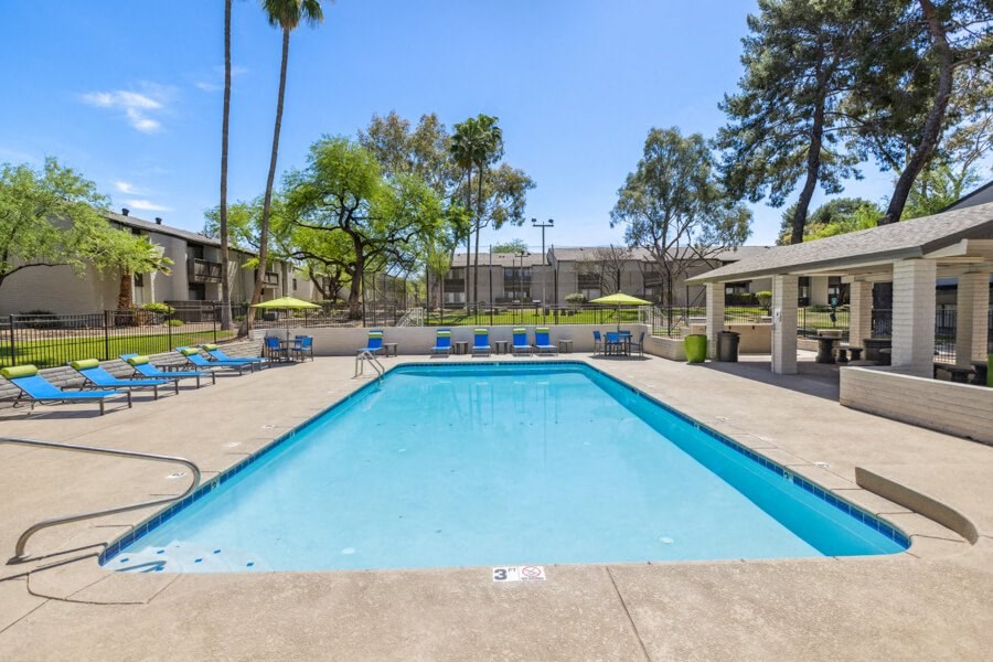 a swimming pool with blue lounge chairs