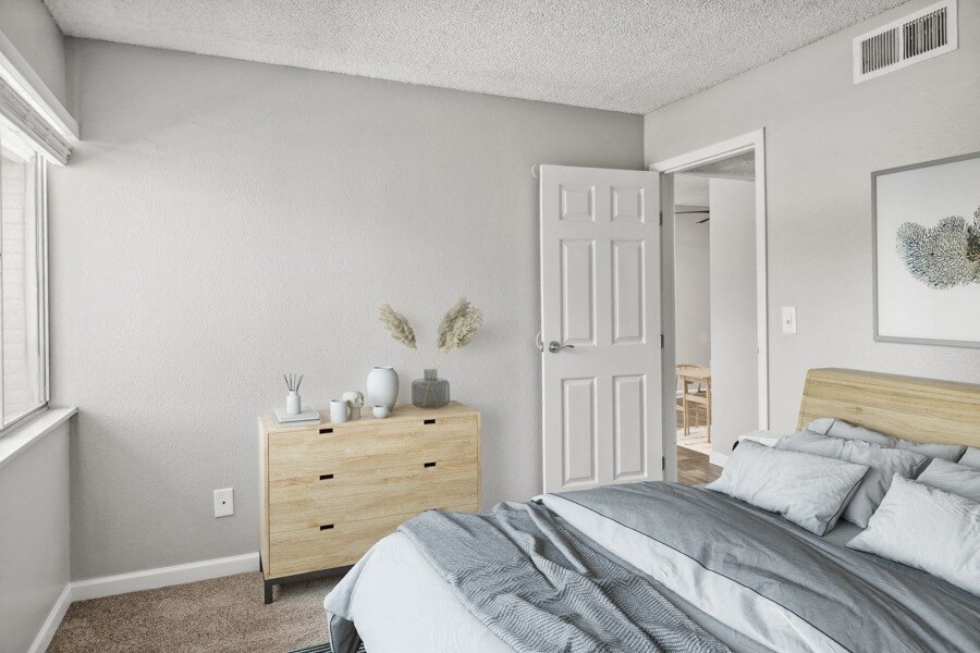 model apartment bedroom with a bed and dresser