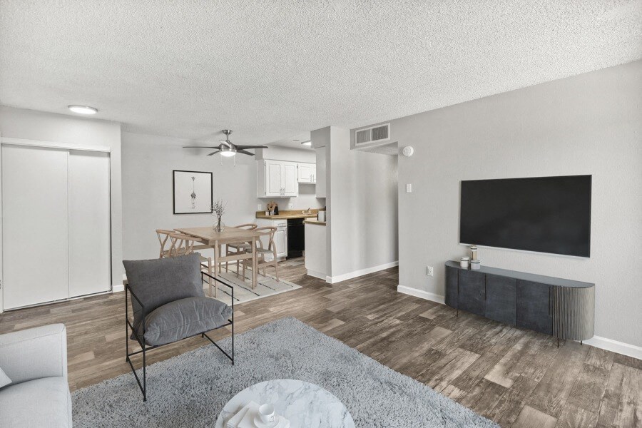 Model apartment living room with a couch a coffee table and a flat screen tv
