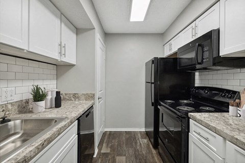 a kitchen with black appliances and white cabinets
