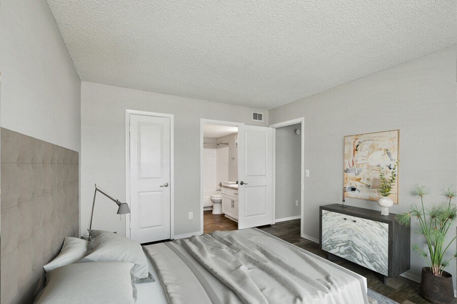 a bedroom with a large bed and a dresser with a vase on it