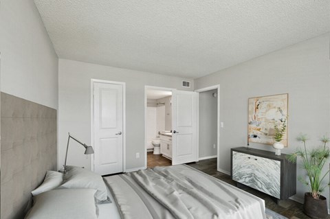 a bedroom with a large bed and a dresser with a vase on it