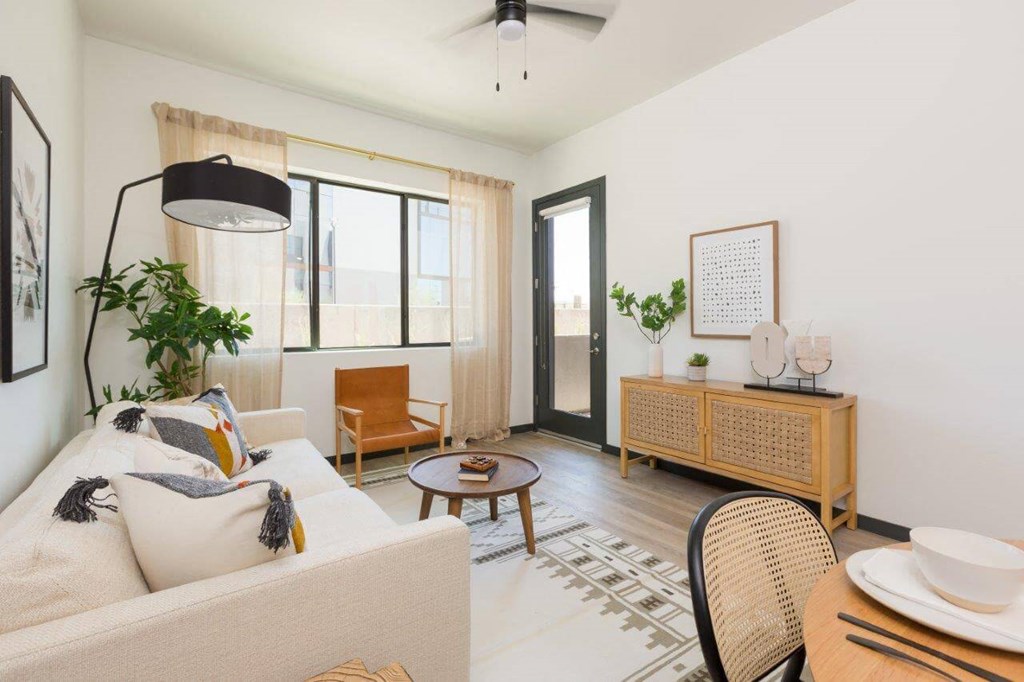 Model living room with large widows and door to balcony/patio