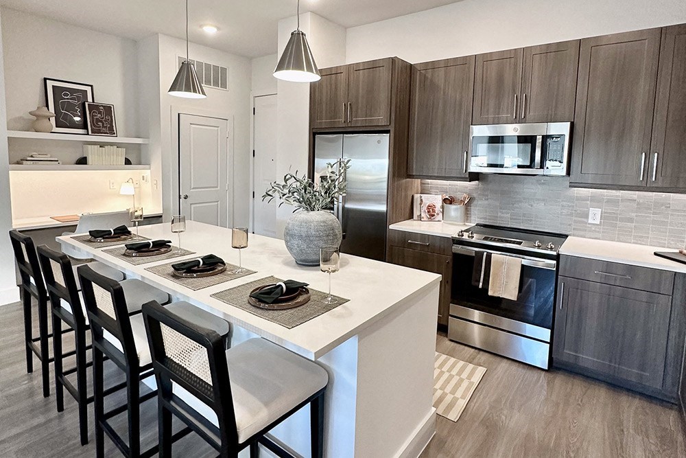a kitchen with a large island with chairs and a counter top