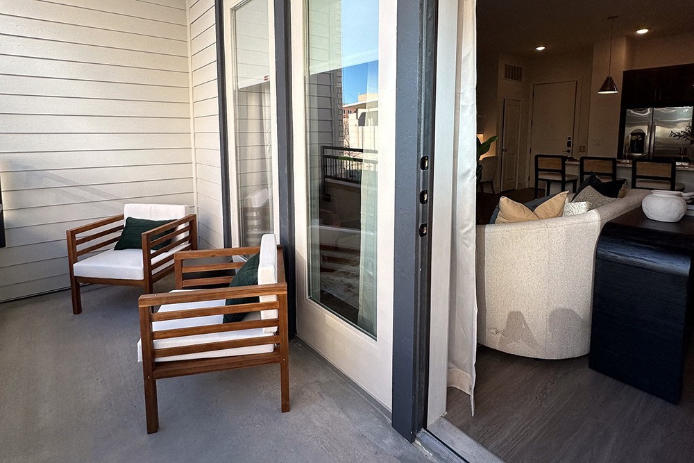 a porch with a couch and chairs and a sliding glass door