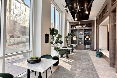 a lobby with a row of tables and chairs and large windows