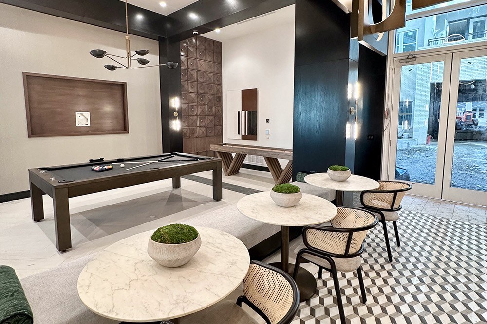 a game room with a pool table and tables