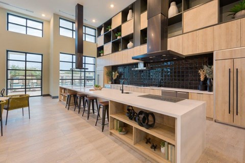 a large kitchen with a long counter and a long bar with chairs