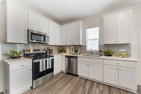 A kitchen with white cabinets and a black stove top oven.