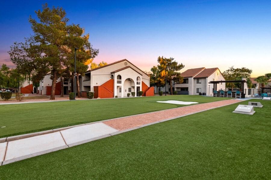 a green lawn in front of a building with a playground at Lore South Mountain, Phoenix, Arizona