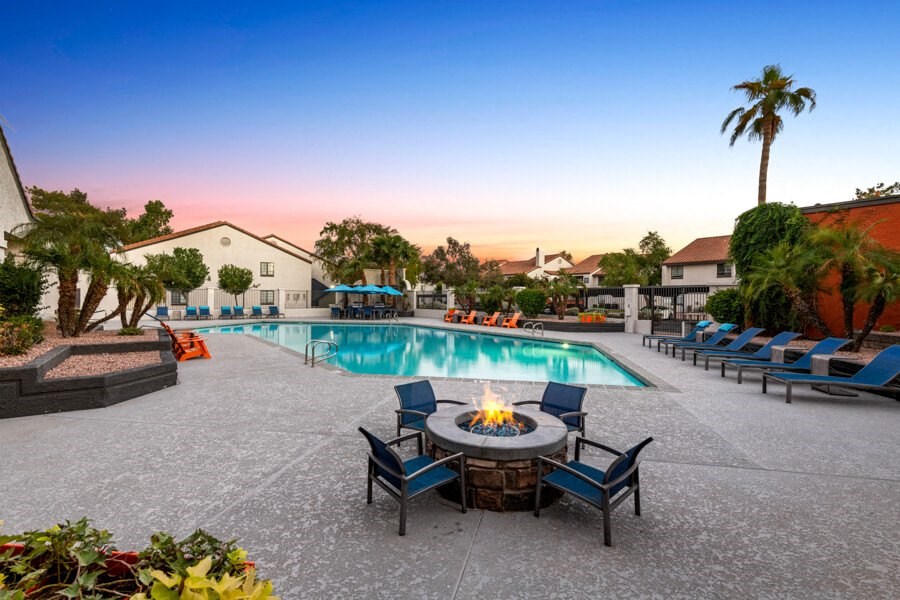 a swimming pool with a fire pit and chairs around it at Lore South Mountain, Phoenix