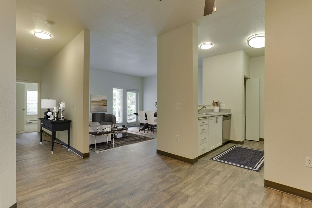 Model Kitchen with White Cabinets and View of Living Room at Landings at Morrison Apartments located in Gresham, OR.