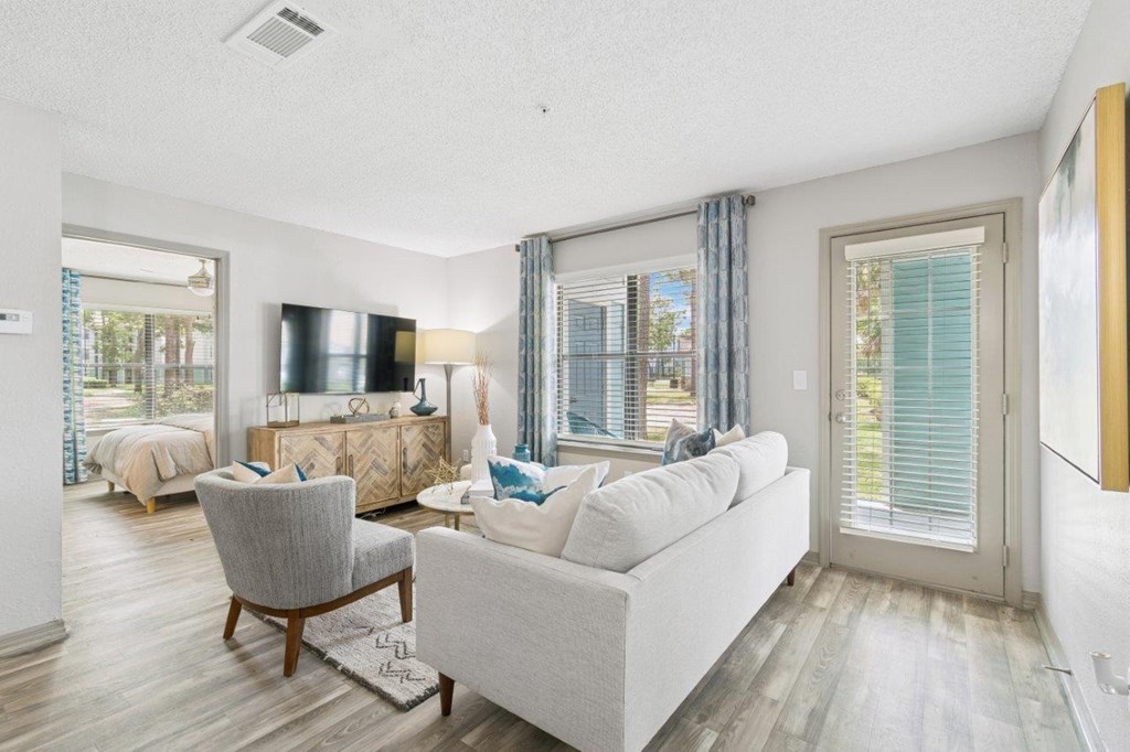 A living room with a grey couch, a chair, and a television.