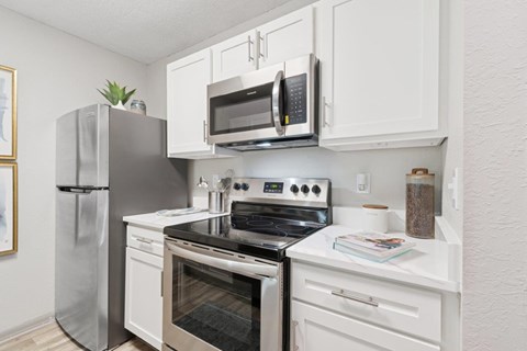 A kitchen with white cabinets and appliances.