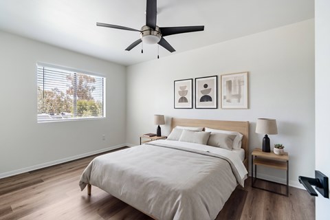 A bedroom with a large bed and a ceiling fan.