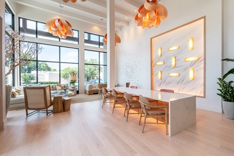 A modern living room with wooden floors and a large abstract painting on the wall.