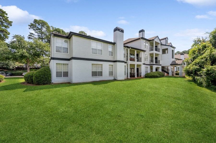 a large green lawn in front of a large white house