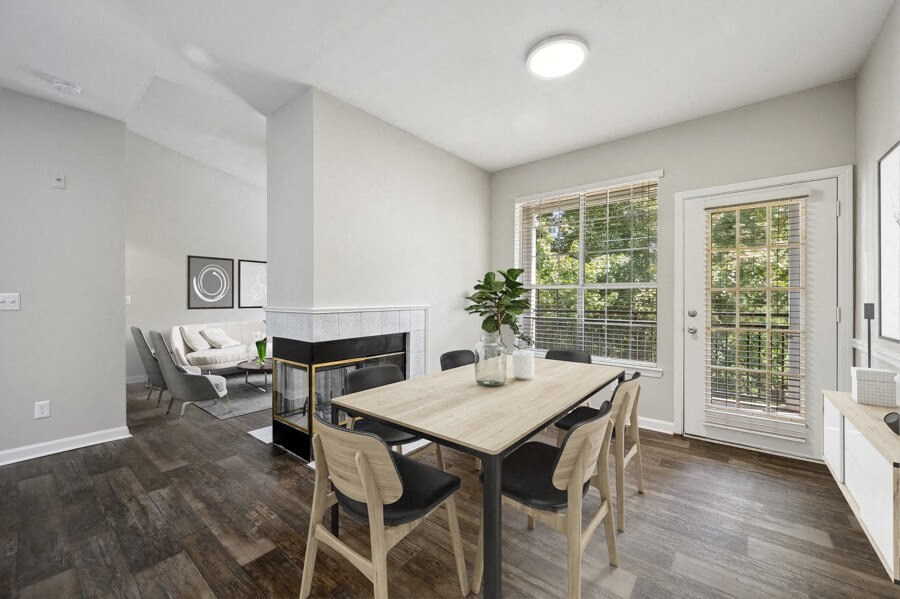 a dining area with a wooden table and chairs and a fireplace in the background