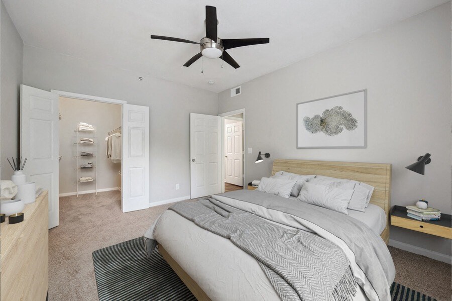 a bedroom with a large bed and a ceiling fan
