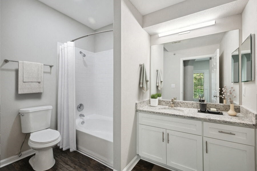 a bathroom with a large mirror and a toilet next to a bathtub with a shower curtain