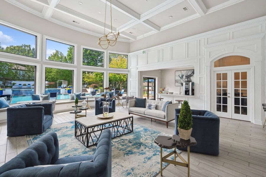 a living room with a coffered ceiling and large windows