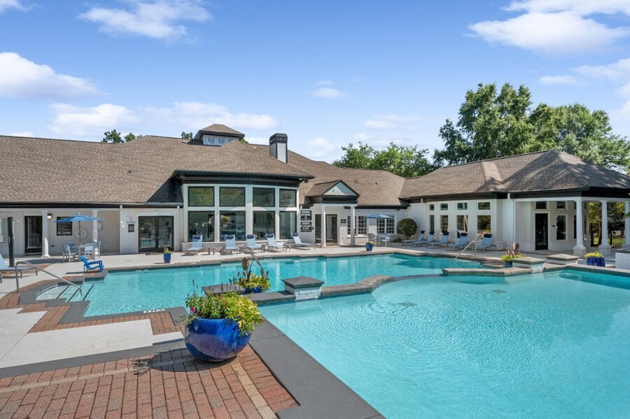 a swimming pool with lounge chairs and a building in the background