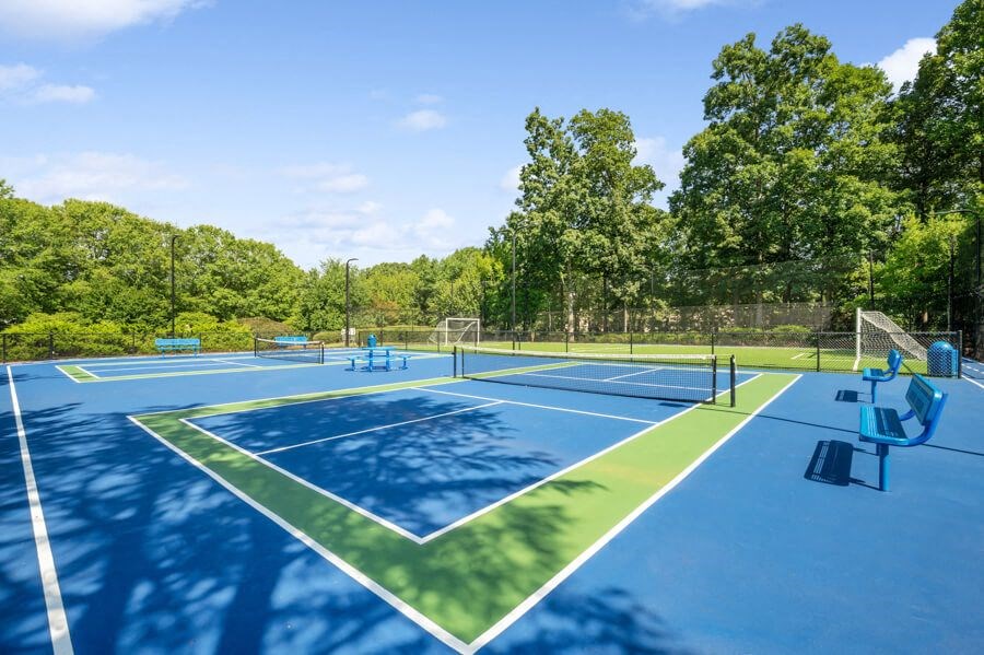 a couple of tennis courts with trees in the background