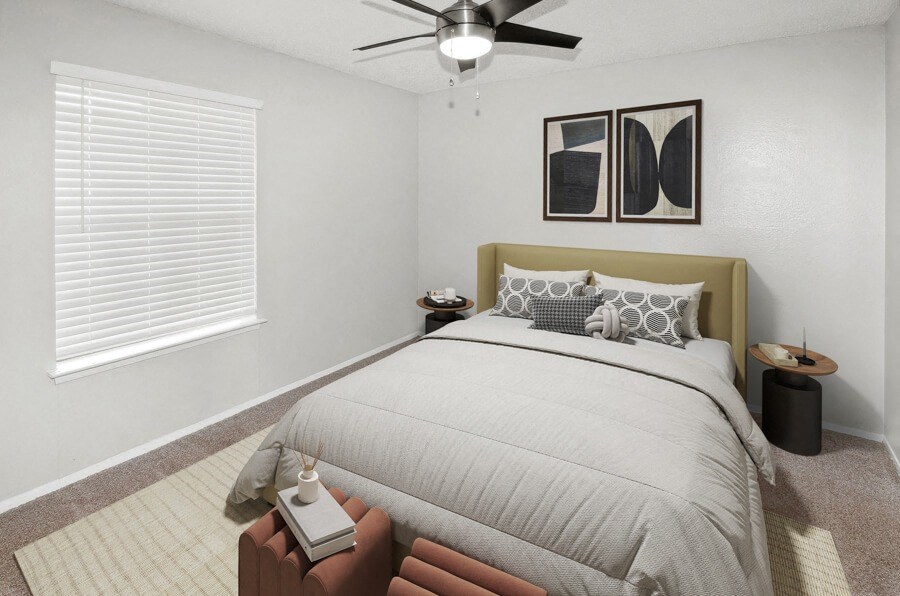Model apartment bedroom with a bed and a ceiling fan