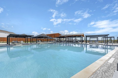 A large outdoor swimming pool with a sun lounger area.