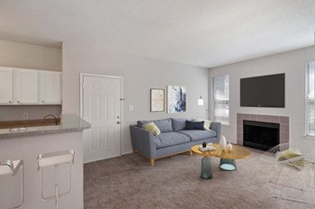 Furnished model living room next to kitchen
