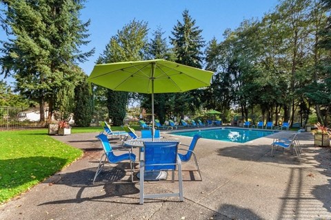 Pool Cabanas & Lounge Swimming pool, cabana with lounge chairs, and beautiful tall pine trees enclosing the area.