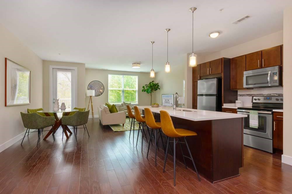 A kitchen with a long island and chairs.
