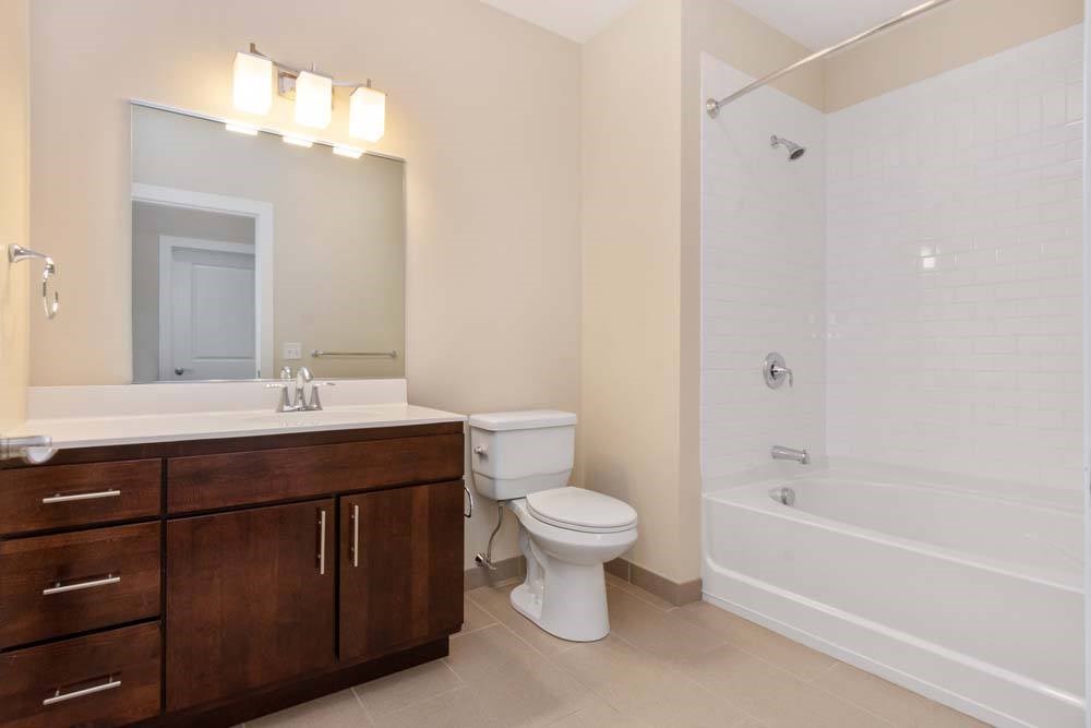 A white toilet sits next to a white sink in a bathroom.
