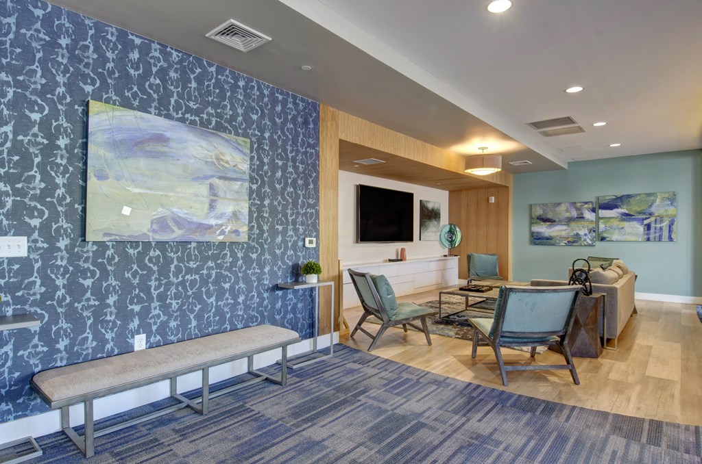 community center with bench, tv, chairs, and blue wallpaper