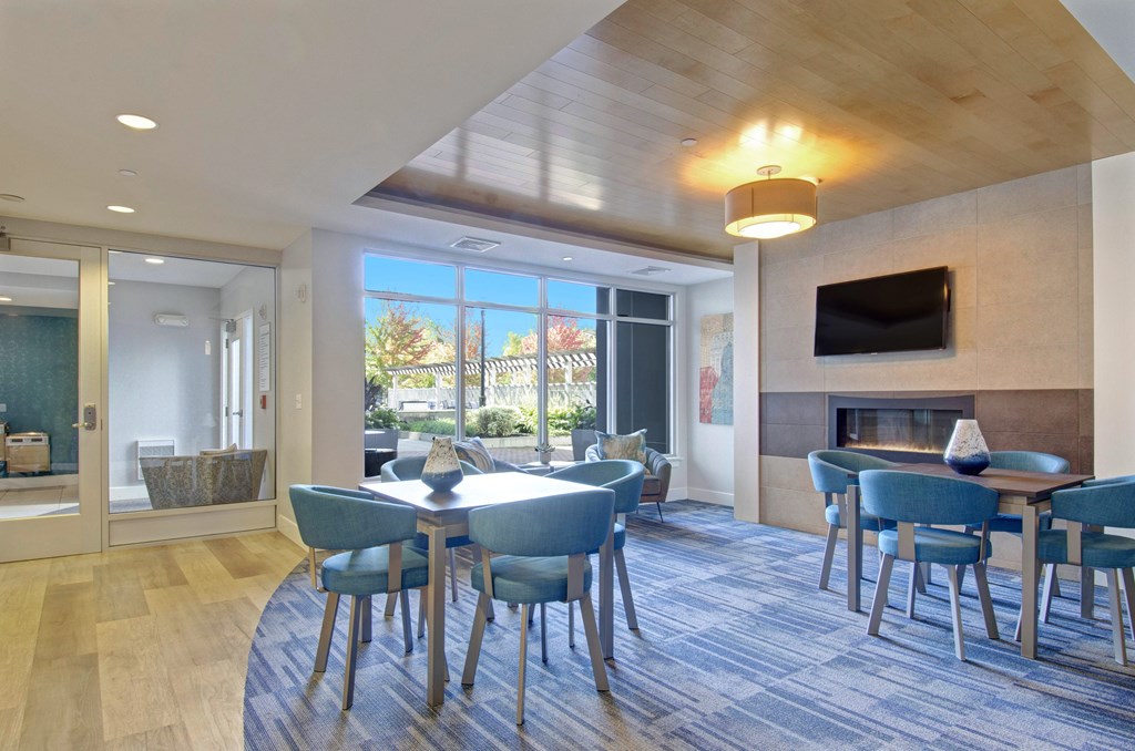 A modern dining room with a wooden ceiling and a fireplace.