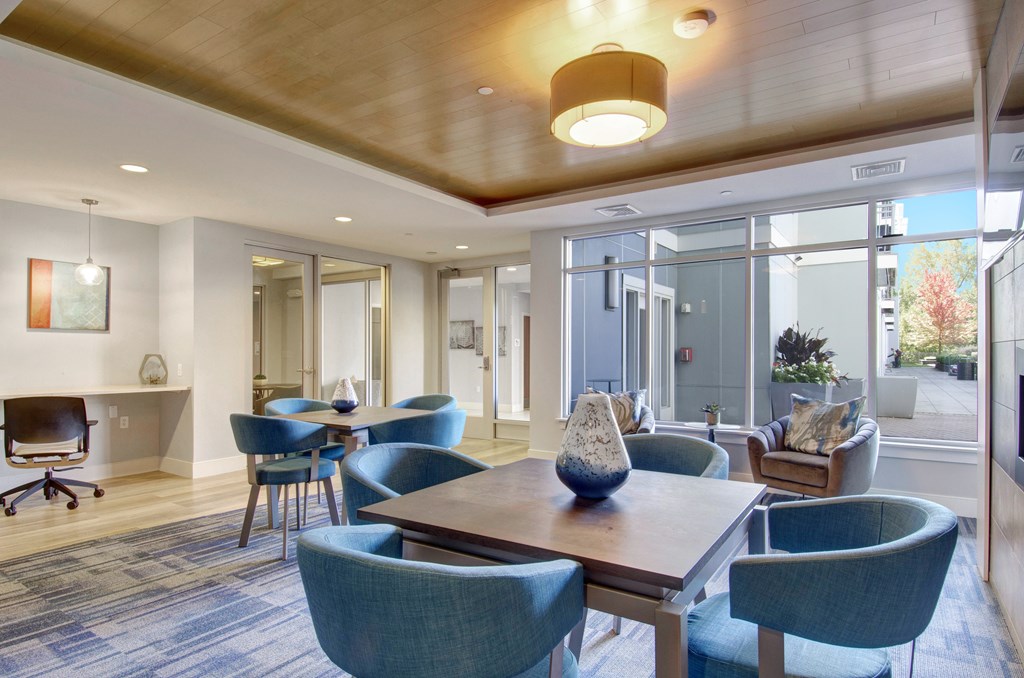 A conference room with a long table and blue chairs.