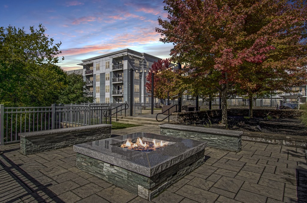 A fire pit sits in the middle of a paved courtyard.