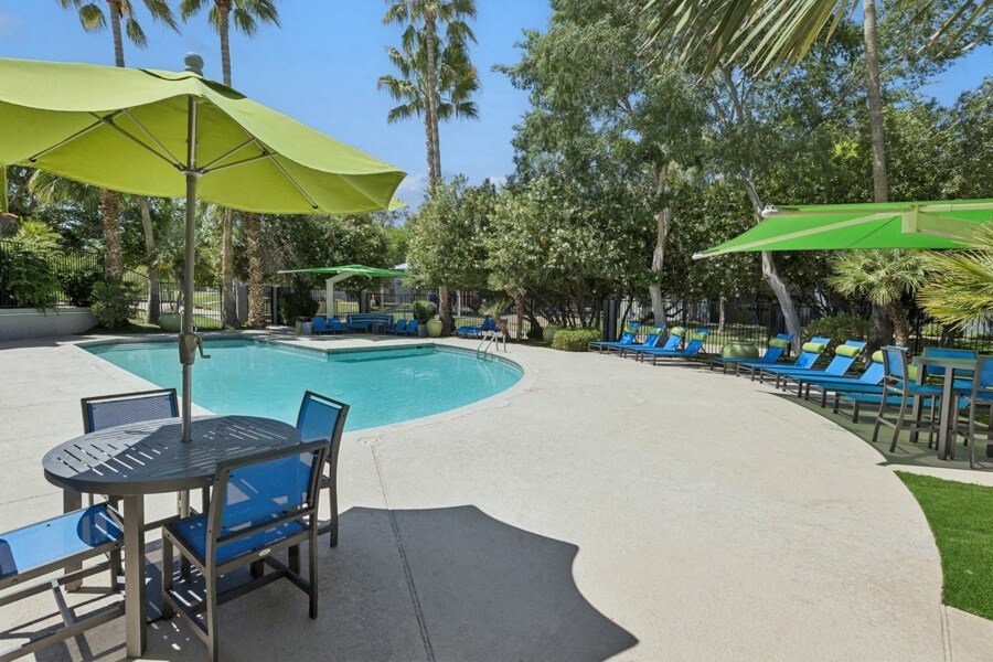 a swimming pool with tables and chairs and umbrellas